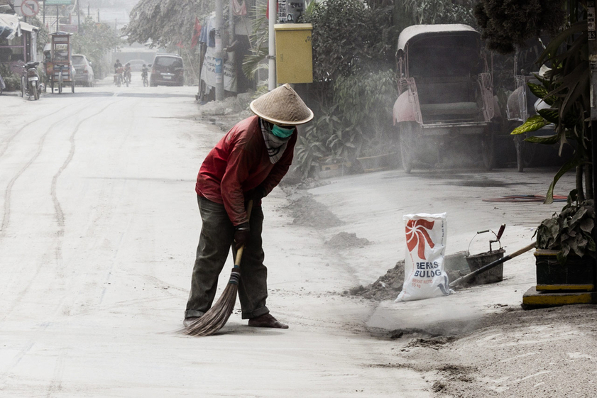 A figure sweeps ash in Yogyakarta during the 2014 eruption of Kelud